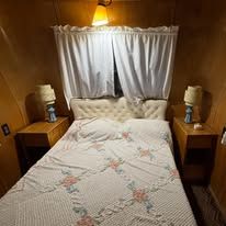 Interior of a restored vintage RV bedroom showcasing mid-century design and craftsmanship preserved at our museum.