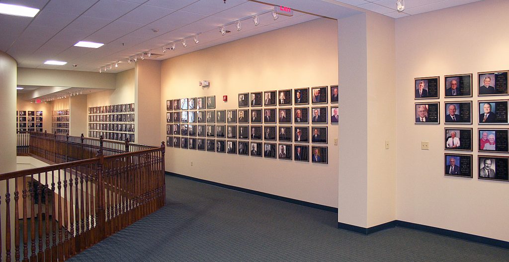 Rows of framed RV/MH Hall of Fame inductee portraits displayed along the museum gallery wall