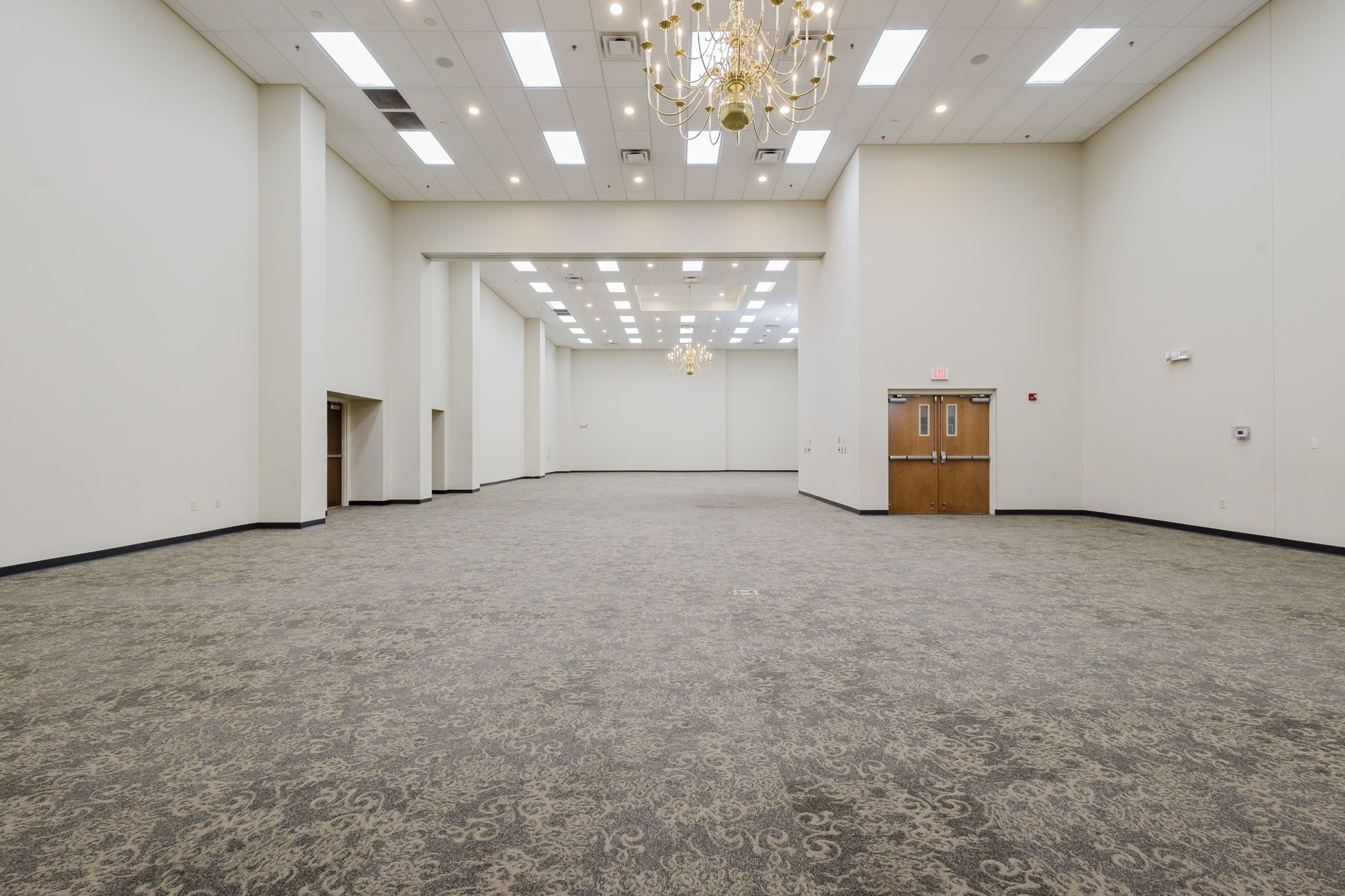 Spacious elegant ballroom at the Northern Indiana Event Center with high ceilings and chandeliers.